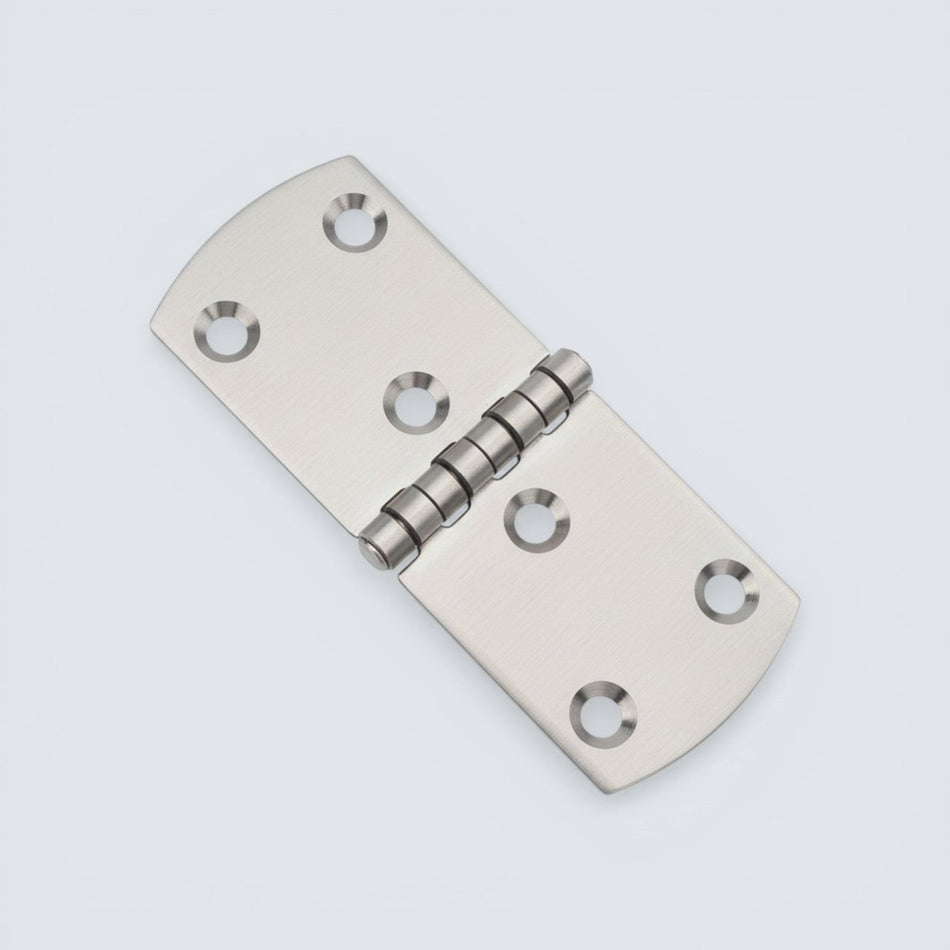 Bild på ett gångjärn i rostfritt stål mot grå bakgrund.