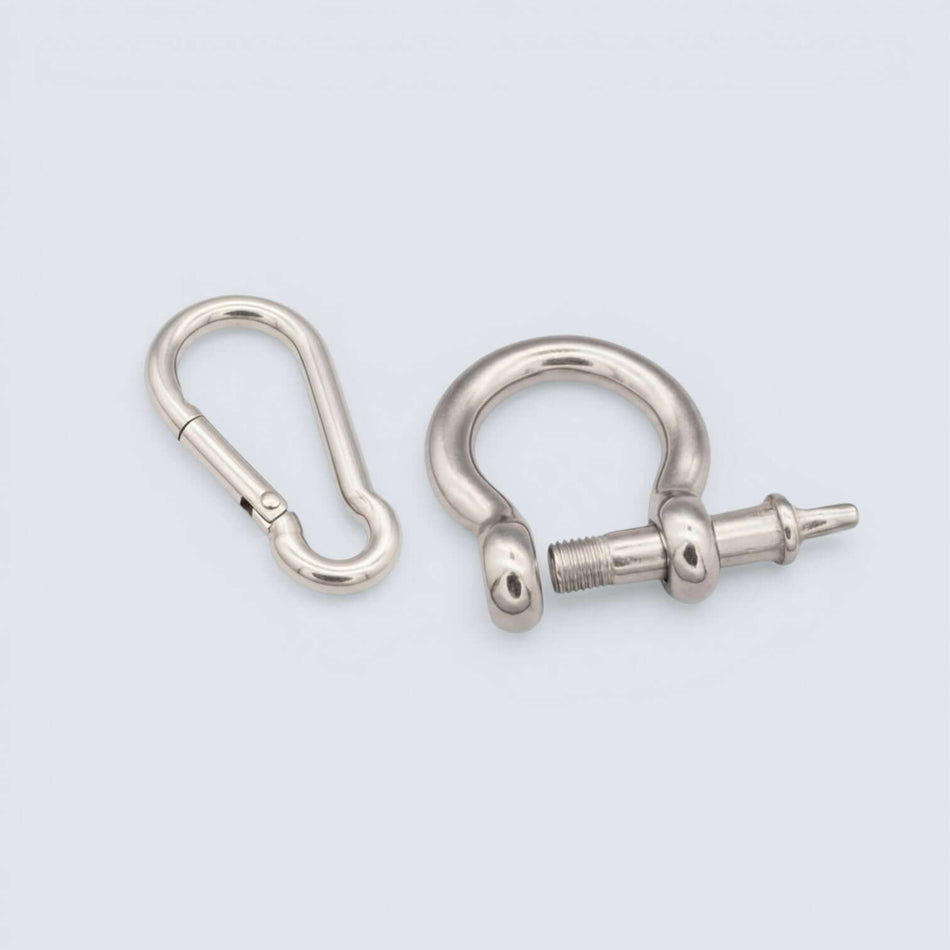 Bild på en karbinhake och schackel i rostfritt stål mor grå bakgrund.