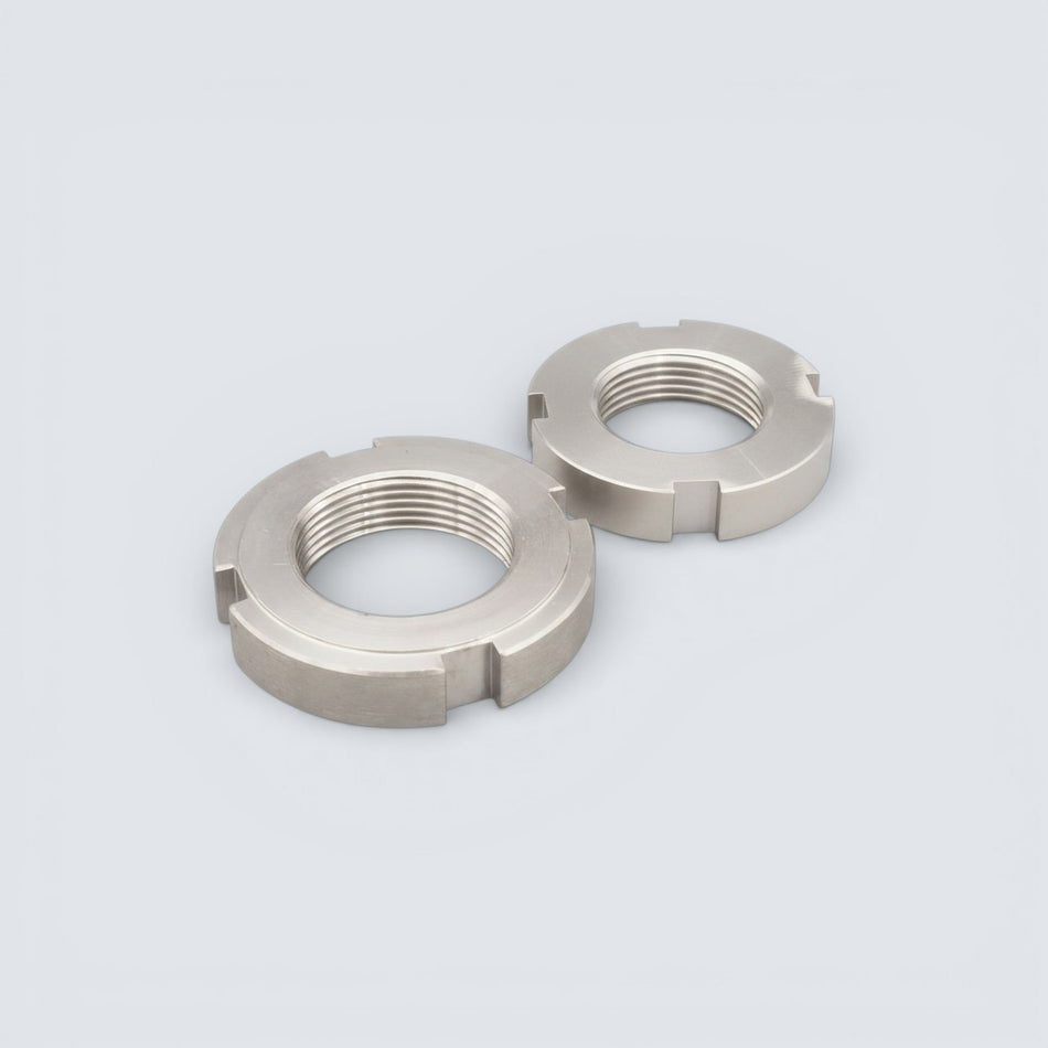 Bild på två hakmuttrar i rostfritt stål.