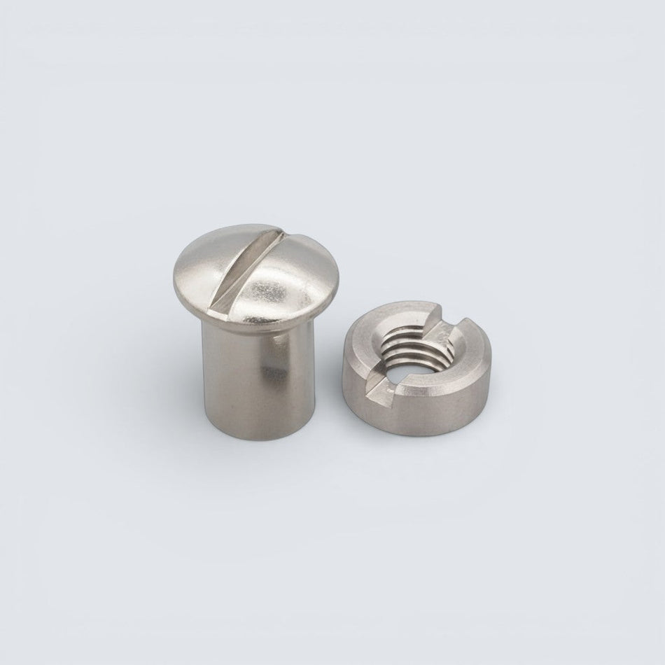 Bild på spårmutter och en slitsmutter i rostfritt stål mot grå bakgrund.