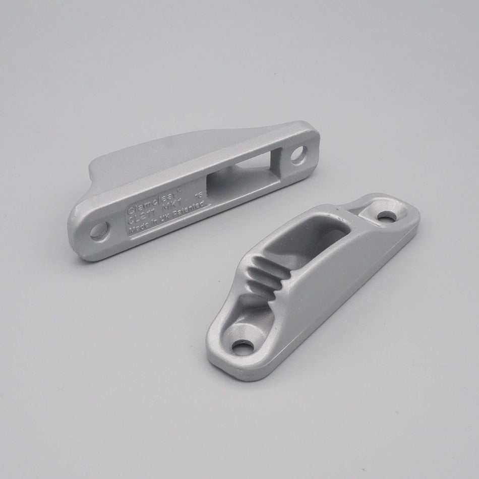 Clamcleat-repklämma i aluminium mot en grå bakgrund.